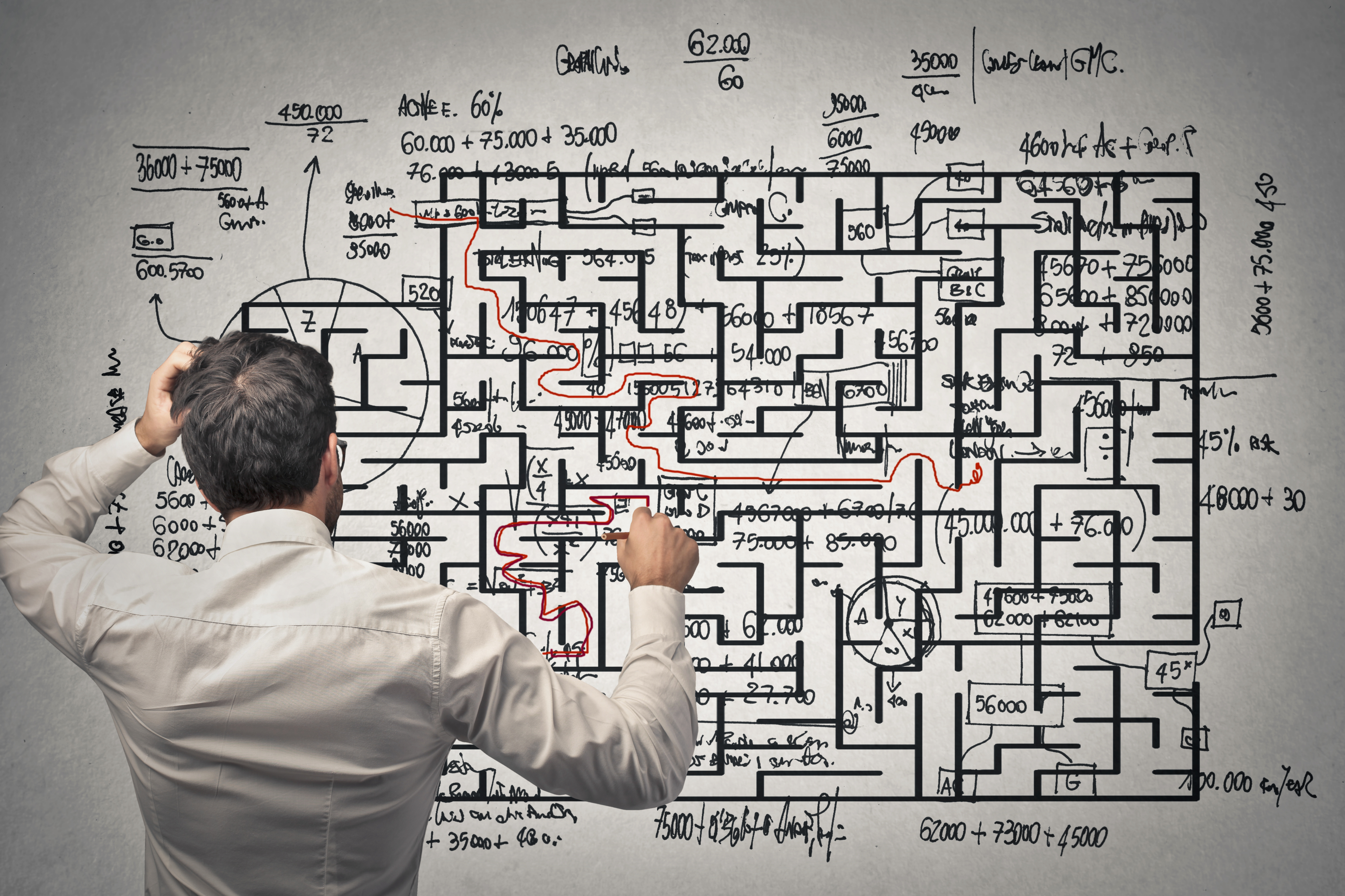 A manager tracing a single red path through a dense maze of figures and calculations